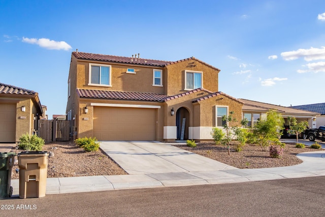 mediterranean / spanish house featuring stucco siding, a tile roof, a gate, driveway, and a garage
