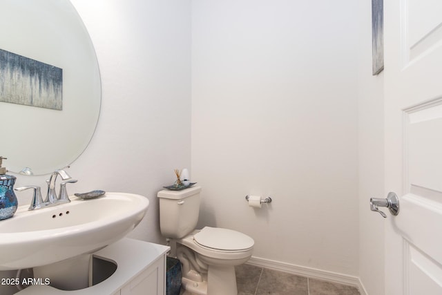 bathroom with toilet, a sink, baseboards, and tile patterned floors