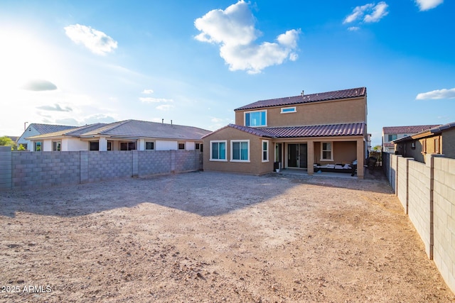 back of property with a fenced backyard, stucco siding, and a patio area