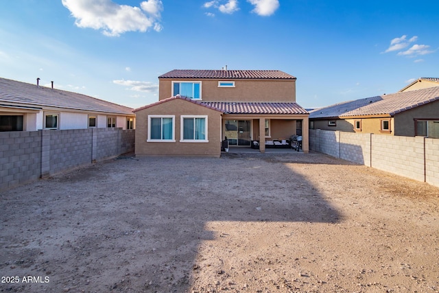 back of property with stucco siding, a tiled roof, a fenced backyard, and a patio