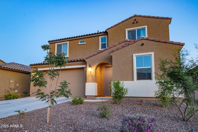 view of front of property with a garage, a tile roof, stucco siding, and driveway