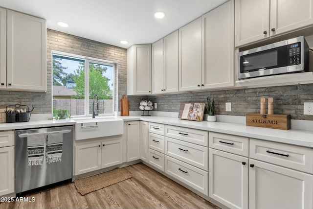 4840 E Sunnyside Dr, Scottsdale, AZ 85254 - kitchen with light countertops, a sink, light wood-style floors, decorative backsplash, and appliances with stainless steel finishes
