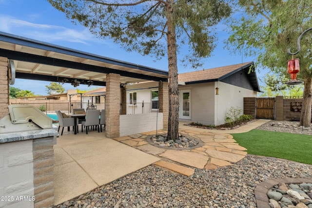 4840 E Sunnyside Dr, Scottsdale, AZ 85254 - back of property with an outdoor kitchen, a gate, a fenced backyard, outdoor dining space, and a patio