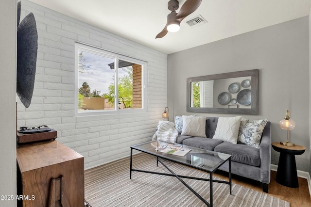 4840 E Sunnyside Dr, Scottsdale, AZ 85254 - living area with plenty of natural light, a ceiling fan, wood finished floors, and brick wall