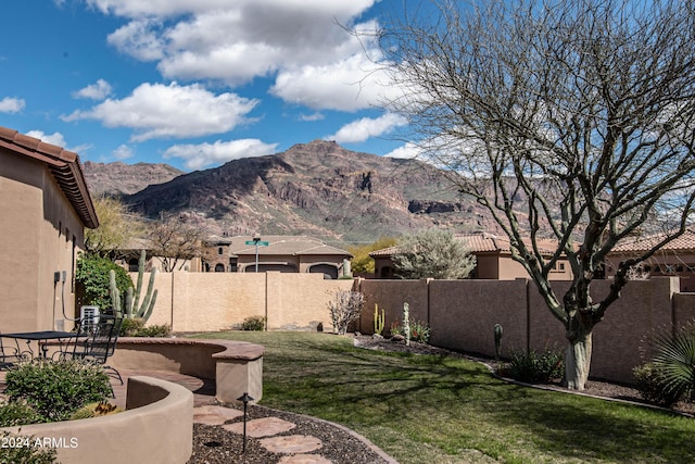 view of yard with a fenced backyard, a mountain view, and a patio area