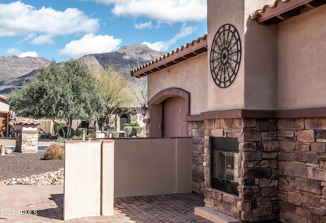 view of patio featuring an outdoor stone fireplace and a mountain view
