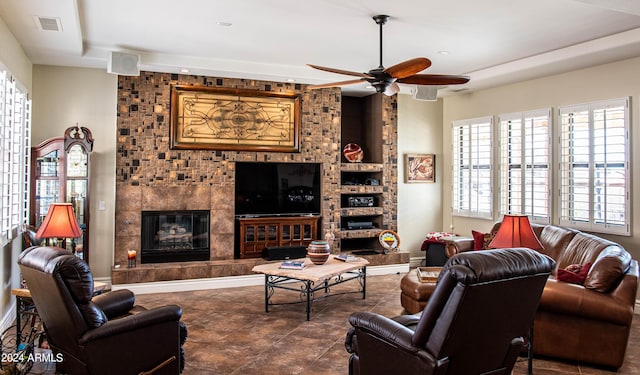 living area with visible vents, a high end fireplace, and a ceiling fan