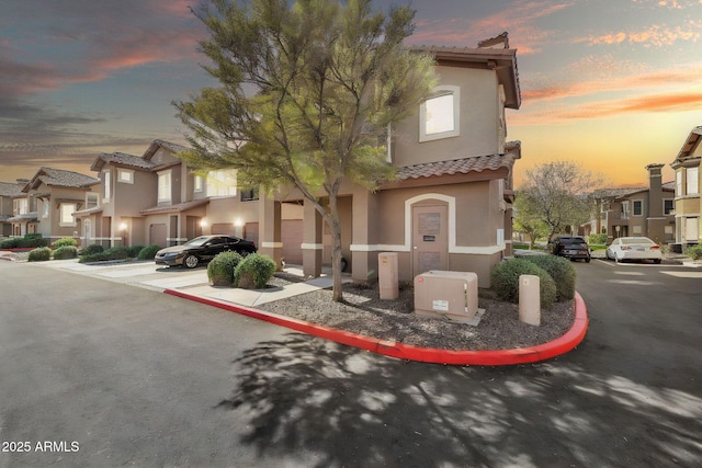 view of front of property featuring a tiled roof, a residential view, and stucco siding