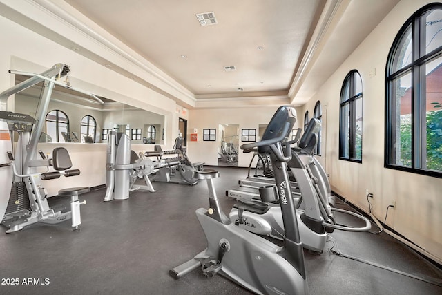 gym featuring visible vents and a tray ceiling