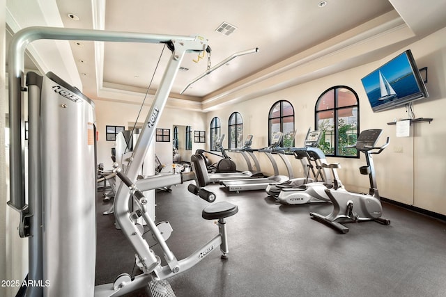 workout area with visible vents and a tray ceiling