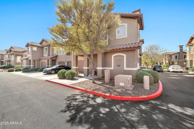 view of front of house featuring a tile roof, a residential view, and stucco siding