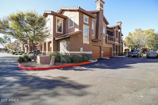 view of building exterior with a garage and a residential view