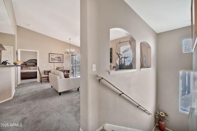 staircase with vaulted ceiling, carpet flooring, and a notable chandelier