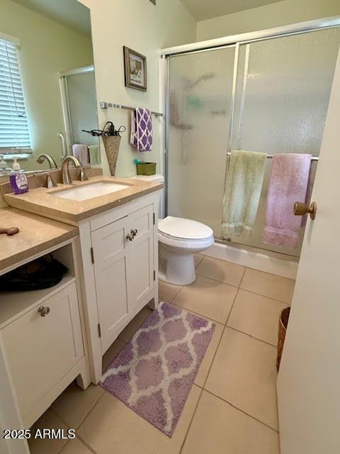 full bath with a stall shower, tile patterned flooring, vanity, and toilet