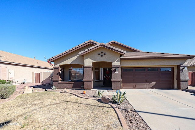 view of front of home with a garage, a tile roof, driveway, and stucco siding