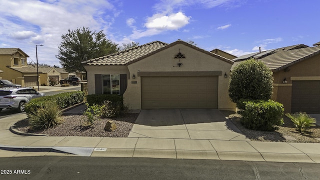 view of front of home featuring a garage, concrete driveway, a tiled roof, and stucco siding