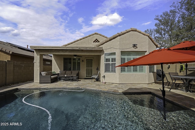 rear view of house featuring a fenced in pool, stucco siding, outdoor lounge area, a patio area, and fence