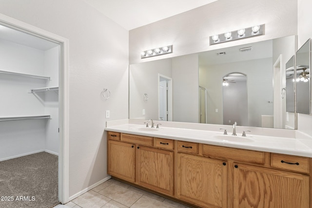 3013 W Via De Pedro Miguel, Phoenix, AZ 85086 - bathroom featuring a ceiling fan, double vanity, a walk in closet, and tile patterned flooring