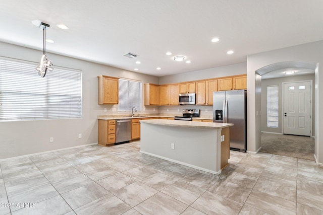 3013 W Via De Pedro Miguel, Phoenix, AZ 85086 - kitchen featuring stainless steel appliances, light countertops, a center island, arched walkways, and recessed lighting