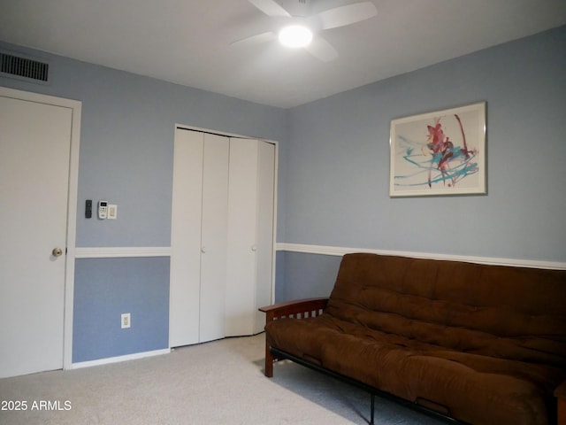 living area featuring light carpet and ceiling fan