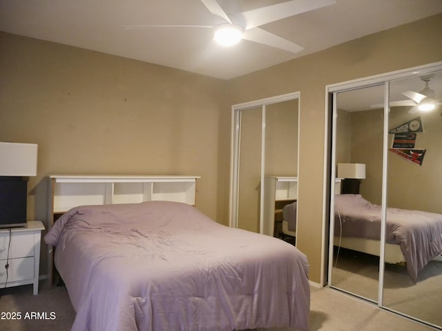 carpeted bedroom featuring ceiling fan and multiple closets