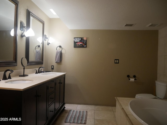 bathroom with toilet, vanity, and tile patterned flooring