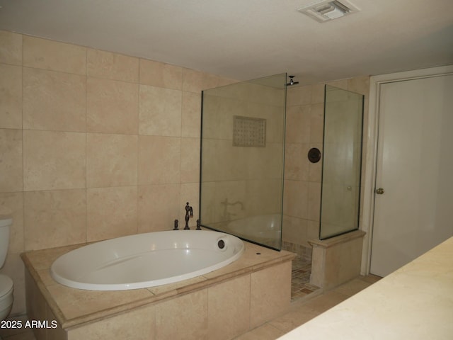 bathroom with tile walls, toilet, and separate shower and tub