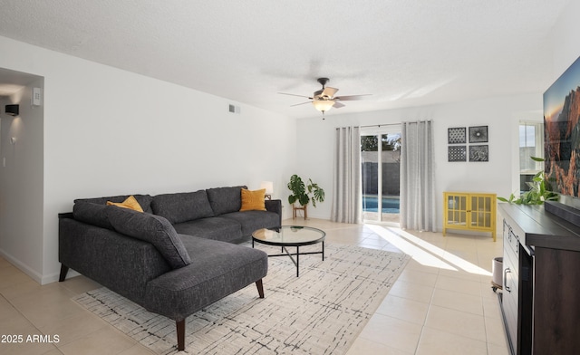 tiled living room with ceiling fan and a textured ceiling