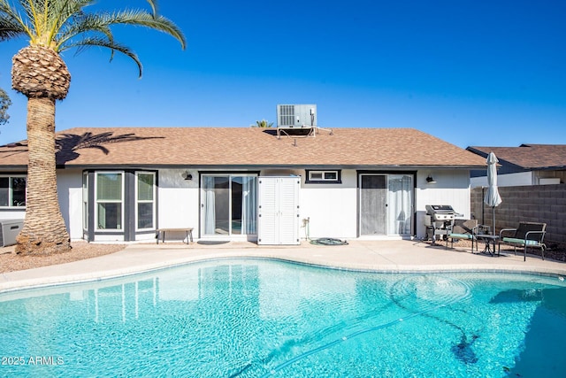 rear view of property with a fenced in pool, central AC unit, and a patio