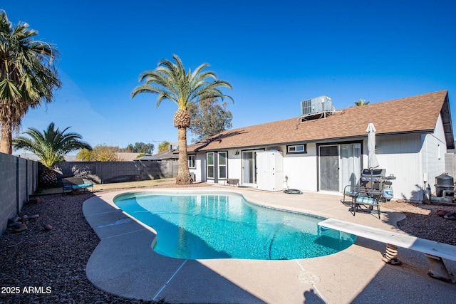 view of pool featuring a diving board, a patio area, and central air condition unit