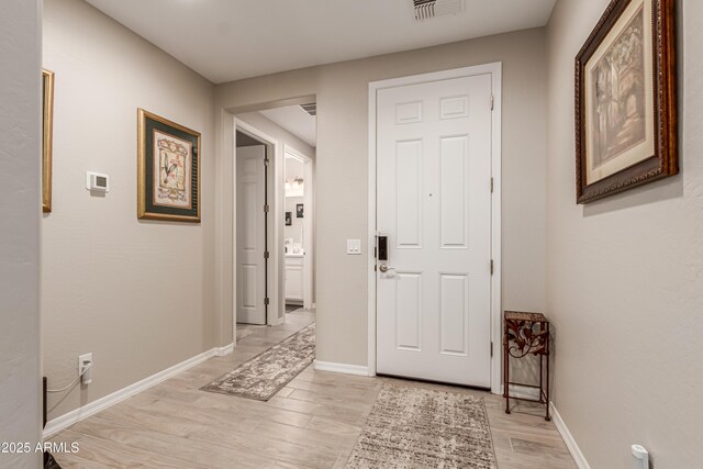 interior space with baseboards, visible vents, and light wood-style floors