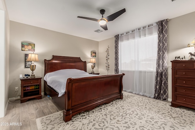 bedroom with light wood-style floors, ceiling fan, and visible vents