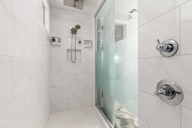 full bath featuring tiled shower and visible vents