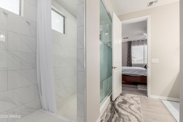 ensuite bathroom with walk in shower, ensuite bath, baseboards, wood finished floors, and visible vents
