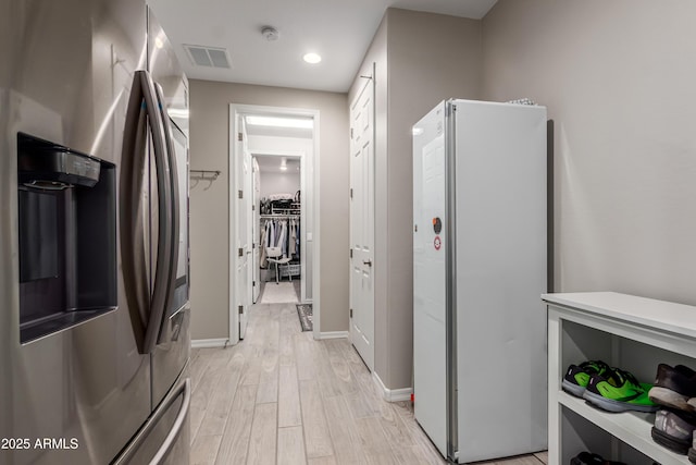 hall with visible vents, recessed lighting, light wood-style floors, and baseboards