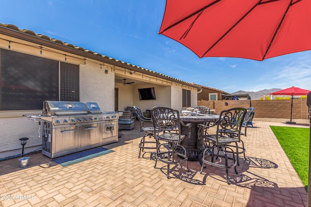 view of patio / terrace featuring fence, outdoor dining area, and a grill