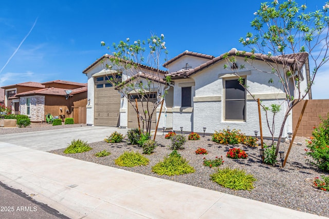 mediterranean / spanish home featuring an attached garage, stucco siding, driveway, and a tiled roof