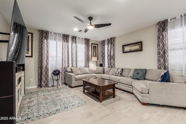 living room with a ceiling fan, visible vents, a healthy amount of sunlight, and light wood-style floors