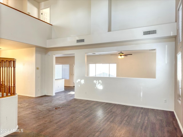 unfurnished room featuring dark hardwood / wood-style floors, ceiling fan, and a high ceiling