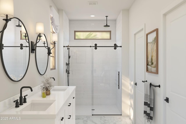 full bathroom with marble finish floor, visible vents, a sink, and a shower stall