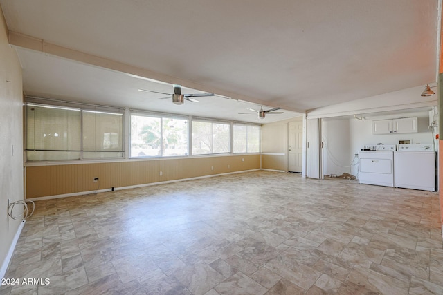 unfurnished living room with ceiling fan, washer and clothes dryer, and vaulted ceiling