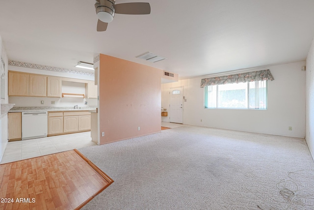 unfurnished living room with light carpet, ceiling fan, and sink