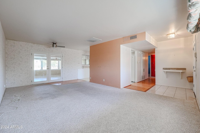 unfurnished living room featuring ceiling fan, french doors, and light tile patterned floors