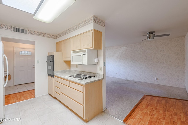 kitchen with light brown cabinetry, white appliances, and light hardwood / wood-style floors