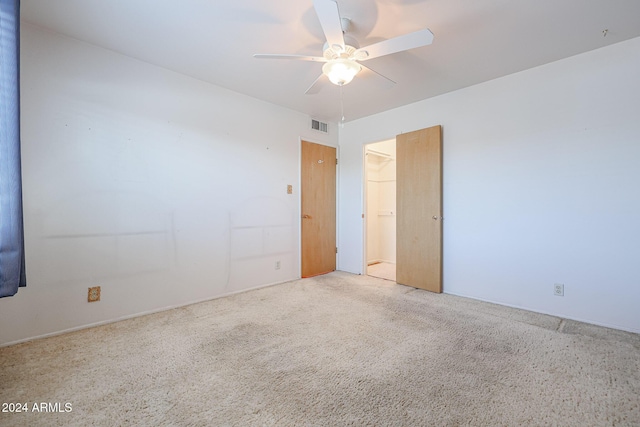 carpeted spare room featuring ceiling fan