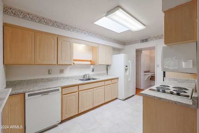 kitchen with light brown cabinets, white appliances, and sink