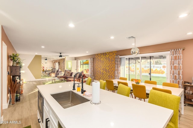 kitchen with a wealth of natural light, decorative light fixtures, ceiling fan, and sink