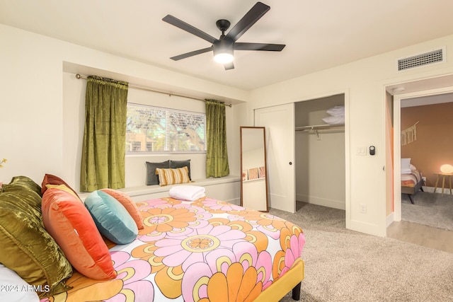 bedroom featuring ceiling fan, light colored carpet, and a closet