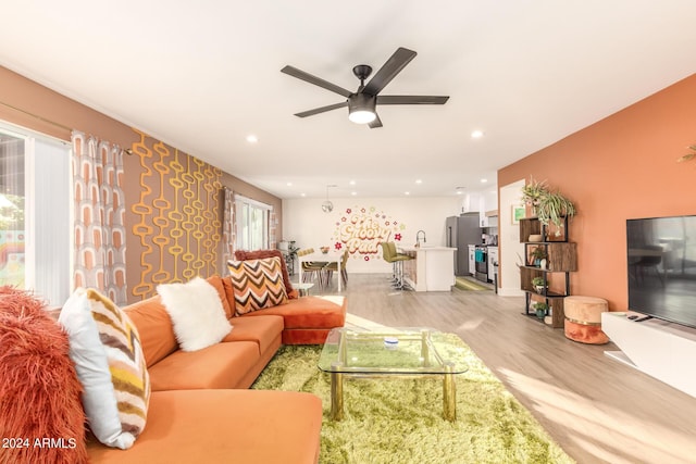 living room with ceiling fan and light wood-type flooring