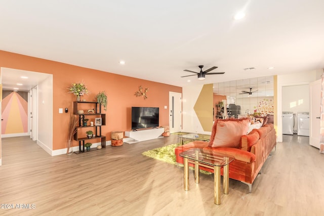 living room with washer and clothes dryer, ceiling fan, and light hardwood / wood-style floors